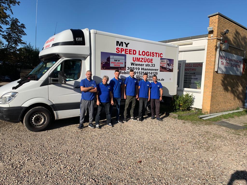 Die Mitarbeiter der My Speed Logistic Umzüge Firma vor Ihrem Transporter mit dem Firmennamen, lächelnd
